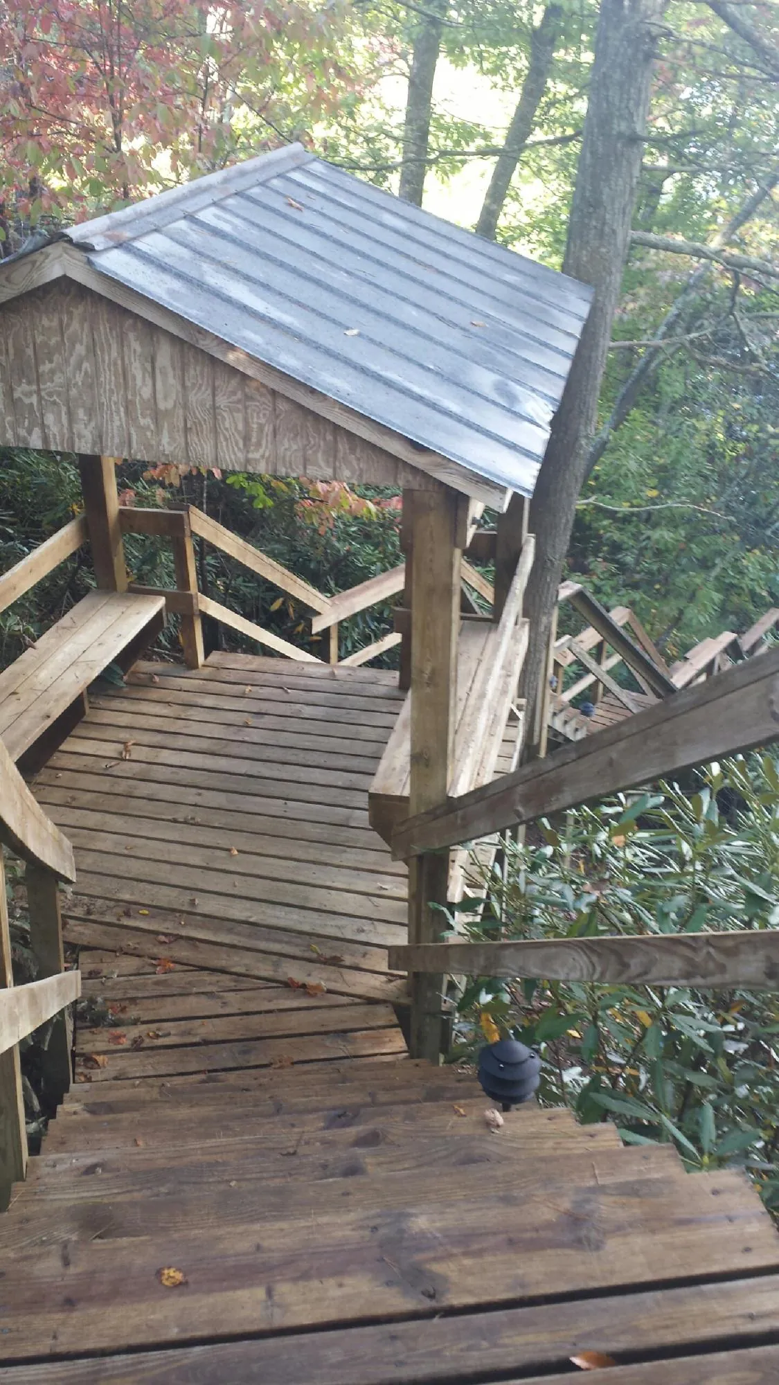 Metal roofed shelter over wooden steps on a wooded walkway — Skylight Repair & Installation work by our crew in Hartville