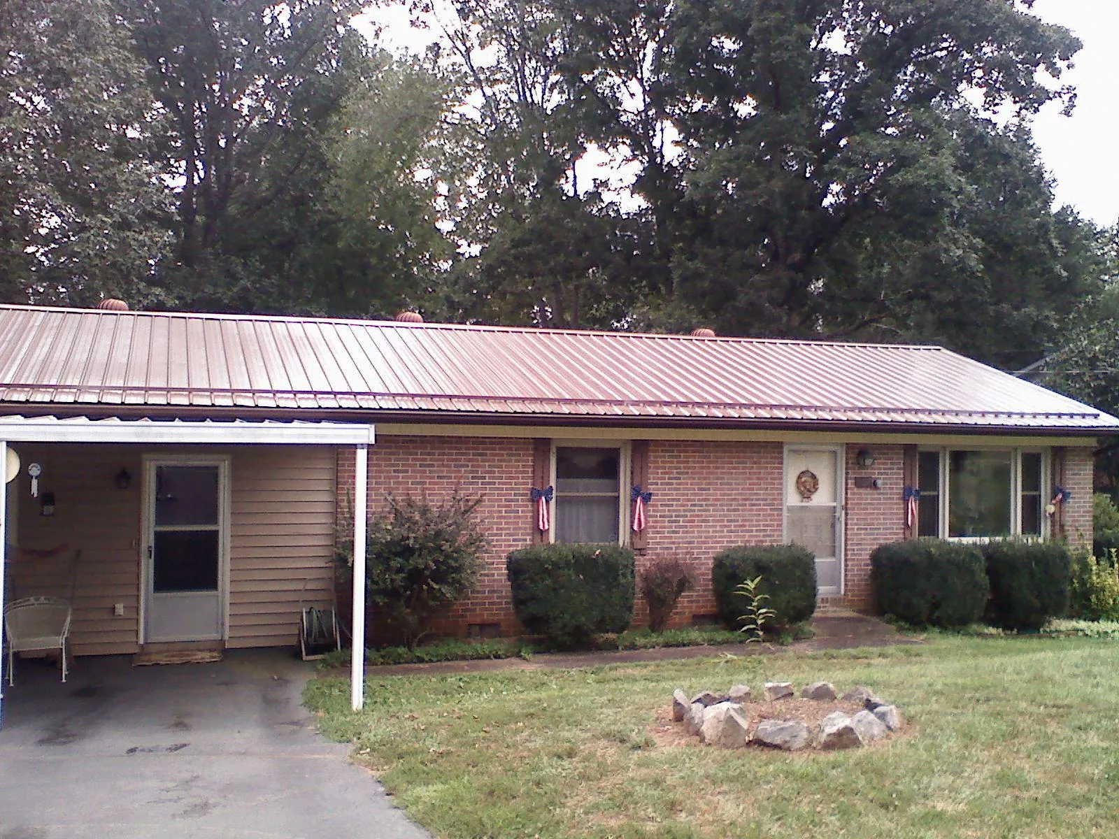 Bronze metal roof and carport on a brick ranch home — Roof Repair work by our crew in Hartville